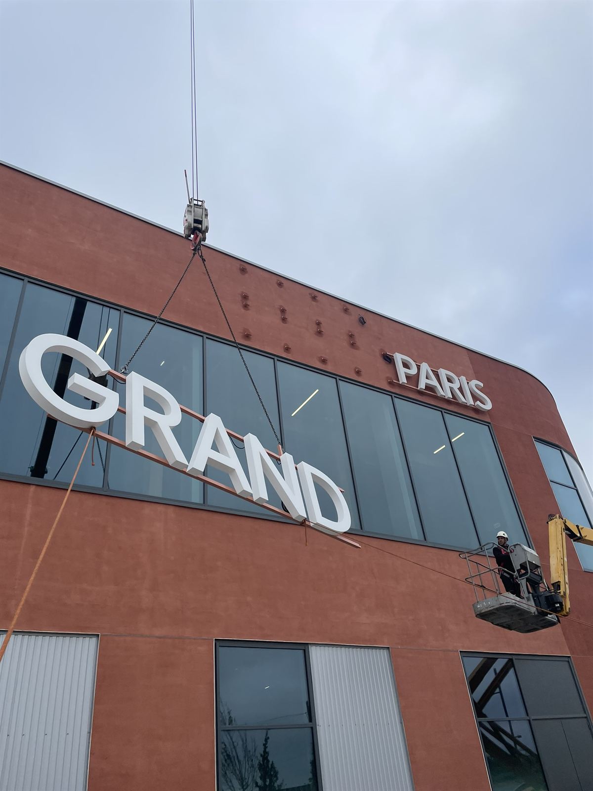 Lettres levées à la grue posé par BSM : façade en brique